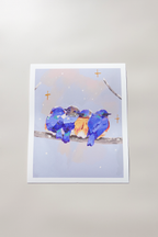 Art print of four plump bluebirds huddled together on a snowy branch, their vibrant blue and orange feathers contrasting a pastel winter sky — subtle sparkles dot the scene, printed on textured fine art paper