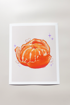 Art print of a vibrant peeled mandarin orange with exposed juicy segments, surrounded by tiny whimsical bunny doodles and lavender sparkles — printed on textured fine art paper and photographed in soft daylight